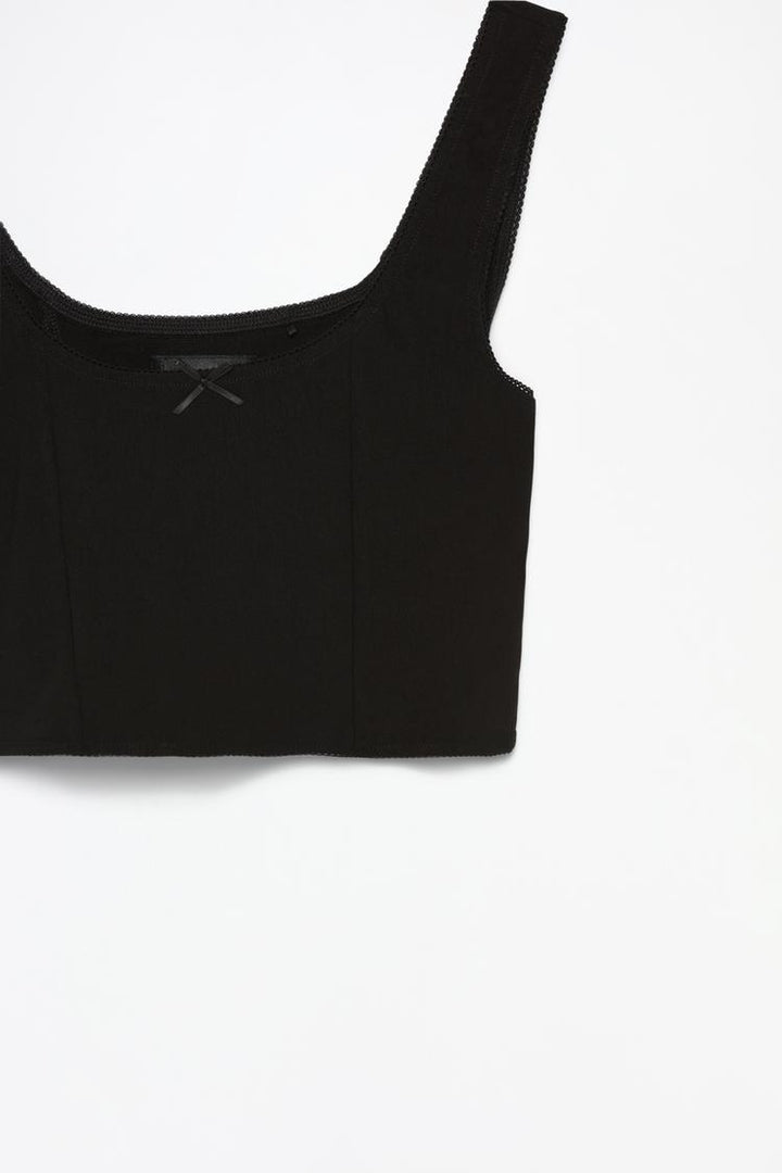 Zoomed-in view of the black rustic strappy top with a bow, highlighting the delicate straps and the charming bow detail for a chic, feminine touch that adds elegance to any outfit.