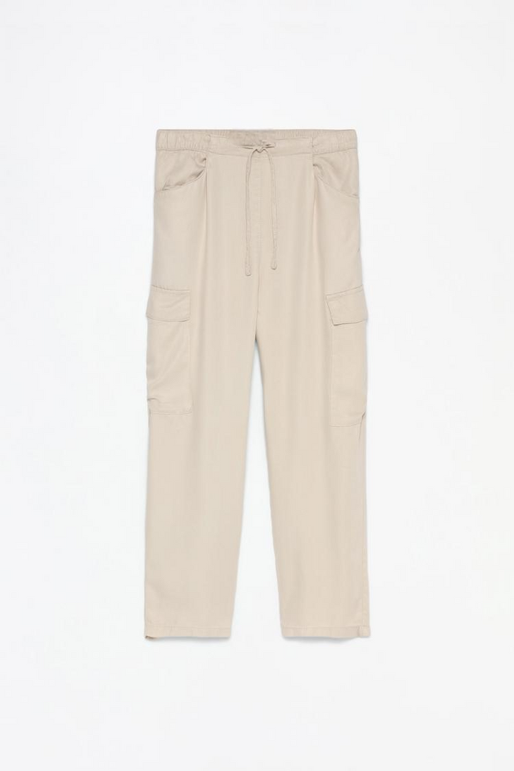 Complete product view of the beige flowing cargo joggers, highlighting the flowing fabric and neutral tone.