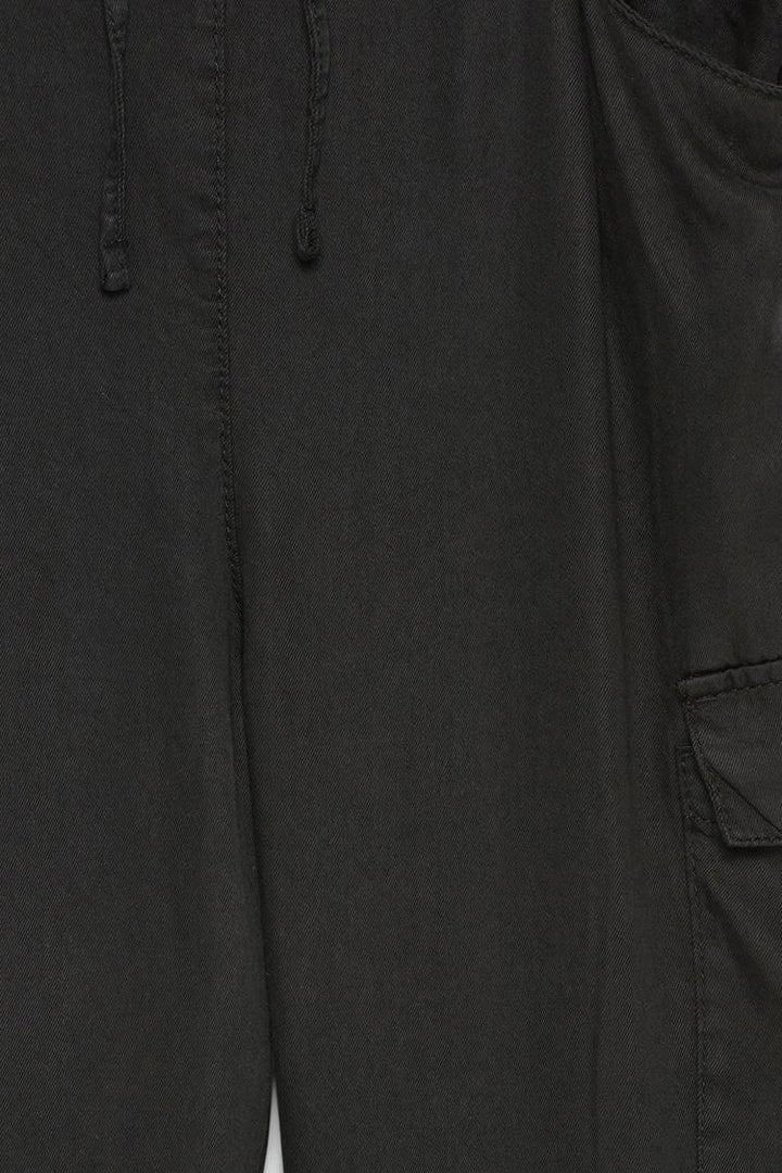Close-up showcasing the premium fabric of the black flowing cargo joggers, emphasizing softness and durability.