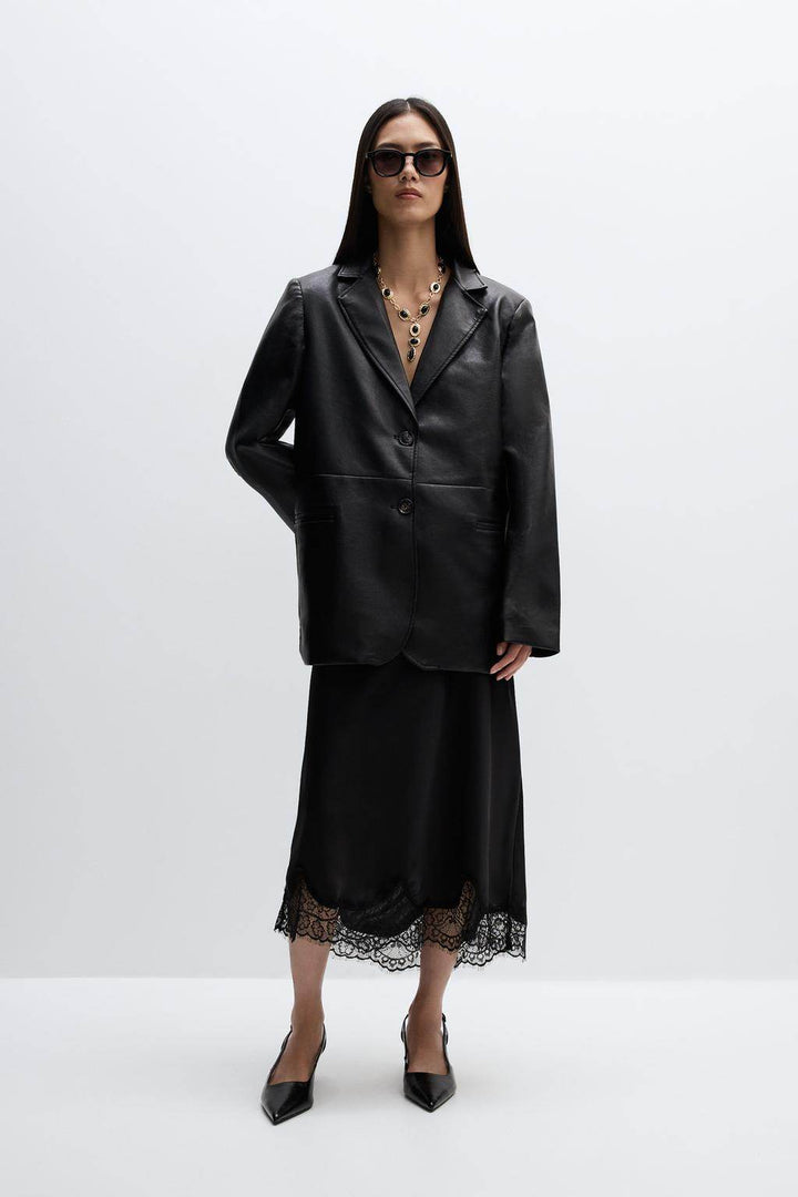 Full body view of a woman wearing a black leather blazer

