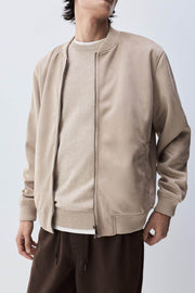 Close-up front view of beige faux suede bomber

