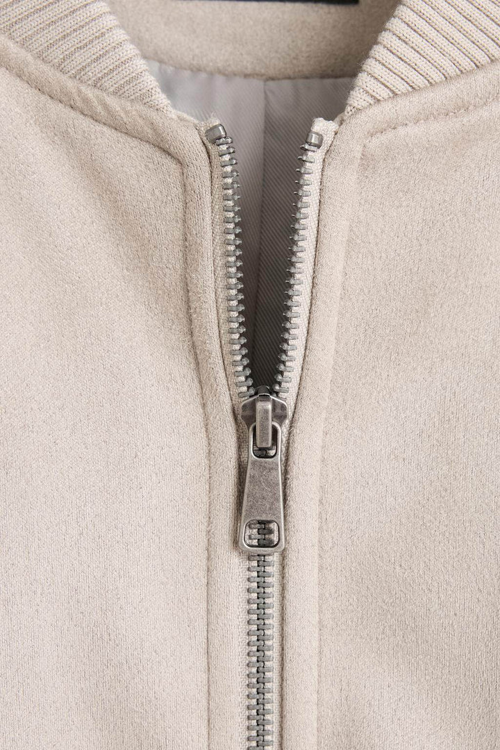 Close-up product image of beige faux suede bomber

