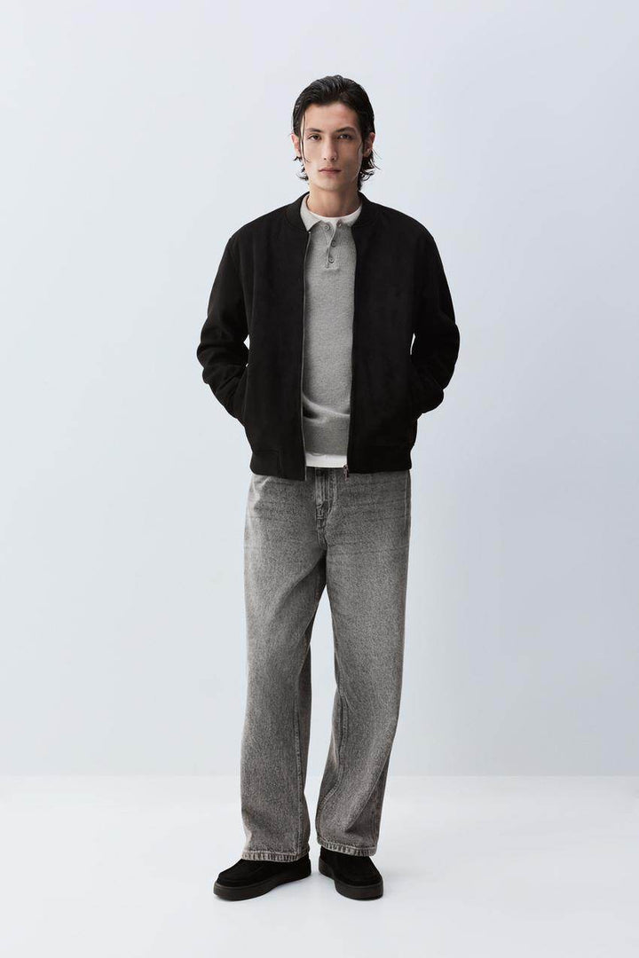 Full body front view of man wearing black faux suede bomber

