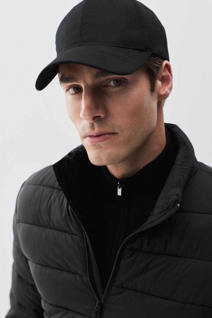 Close-up front view of black lightweight puffer jacket

