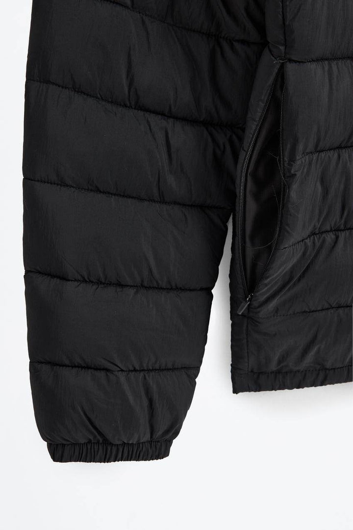 Close-up of black lightweight puffer jacket fabric texture

