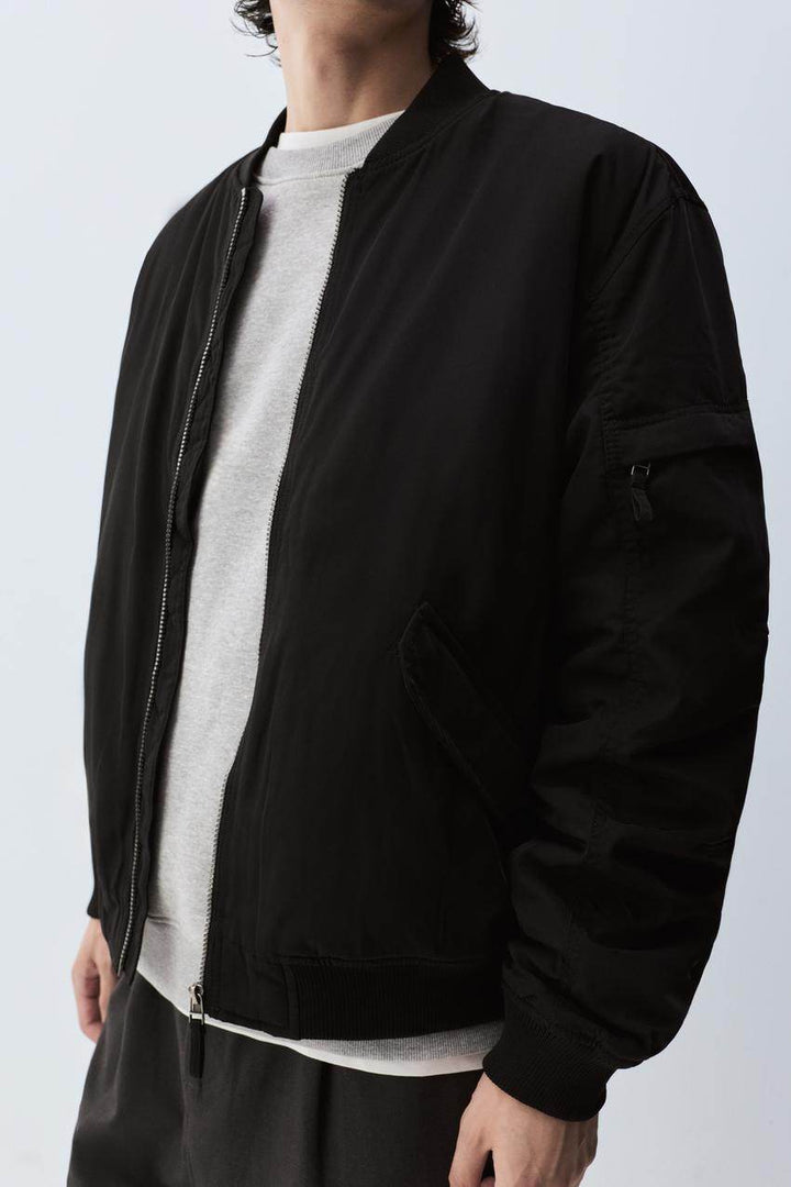 Close-up front view of black padded bomber jacket

