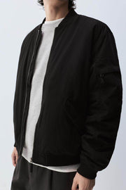 Close-up front view of black padded bomber jacket

