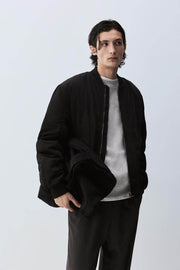 Front view of men's black padded bomber jacket

