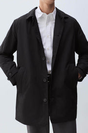 Front view of men's black padded trench coat

