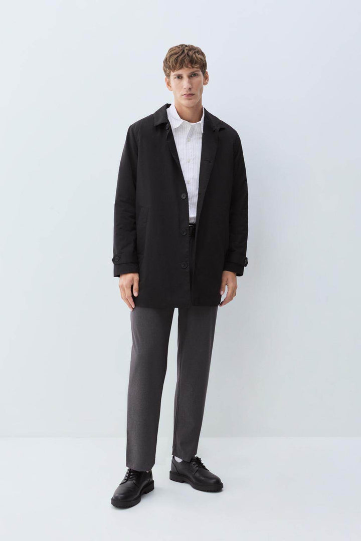 Full body front view of man wearing black padded trench coat

