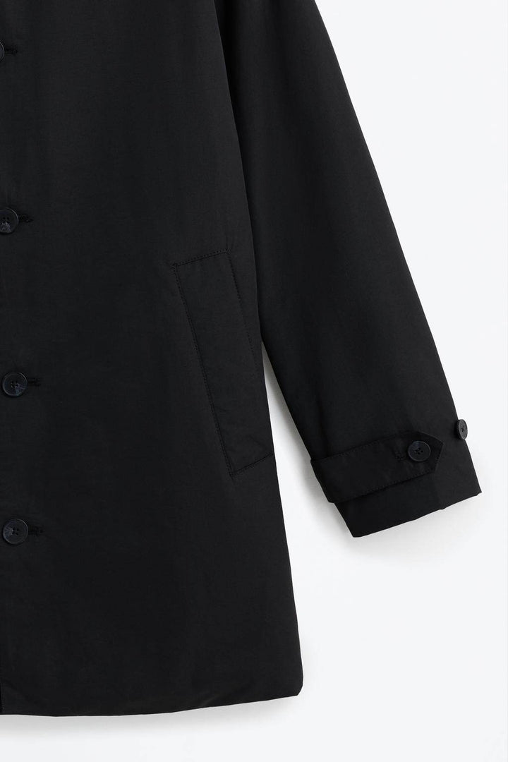 Close-up of black padded trench coat fabric texture

