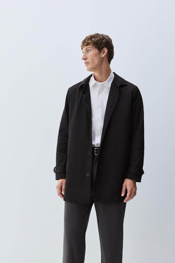 Model side view showcasing black padded trench coat

