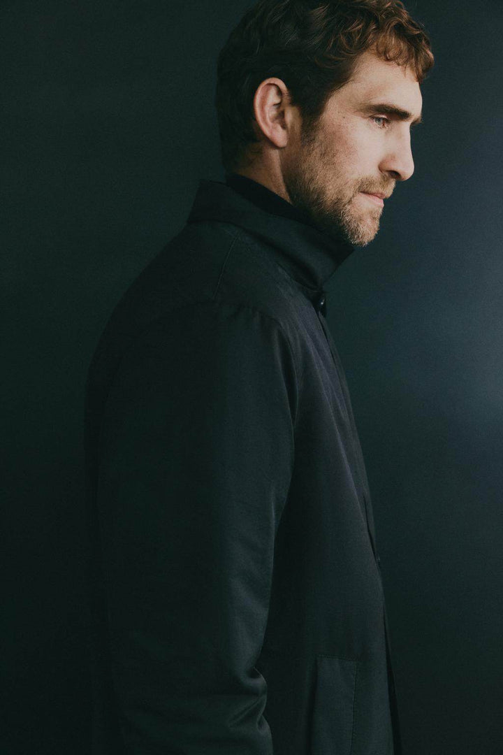 Side view of men's black padded trench coat

