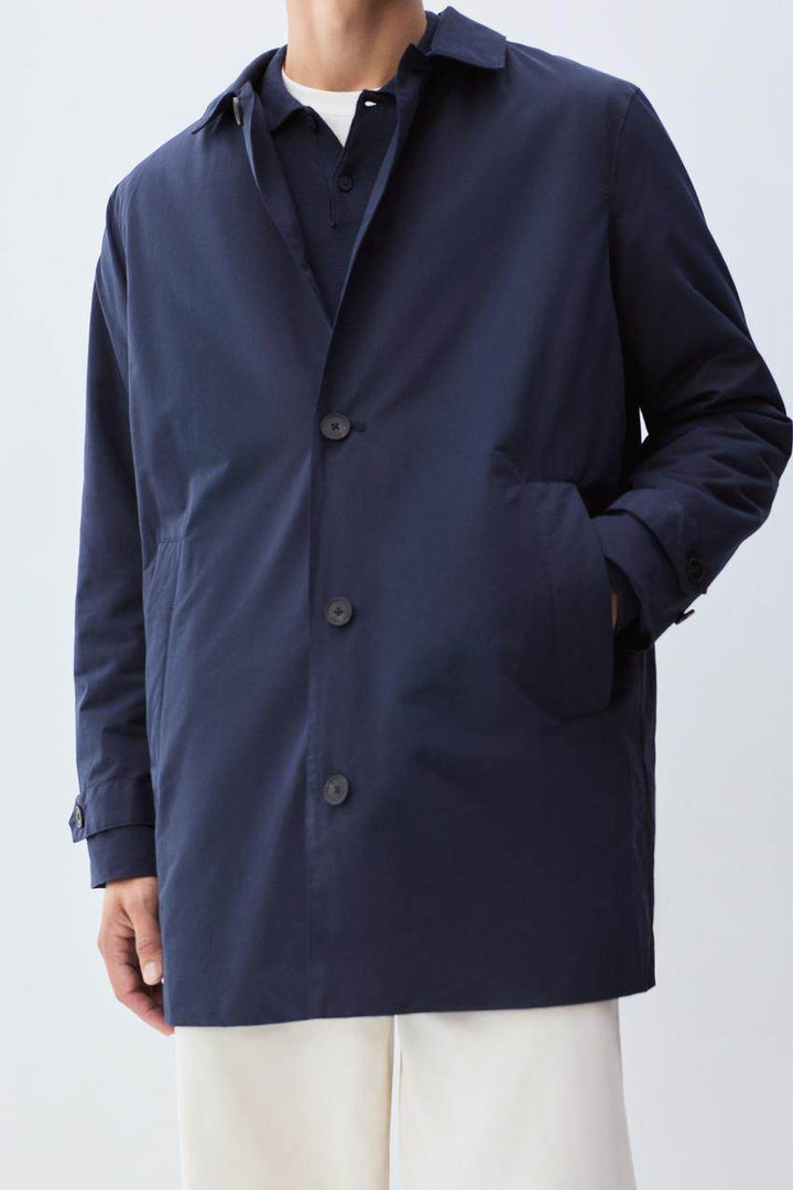 Front view of men's blue padded trench coat


