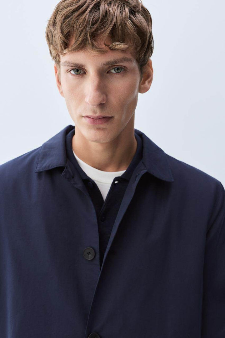 Close-up front view of navy padded trench coat

