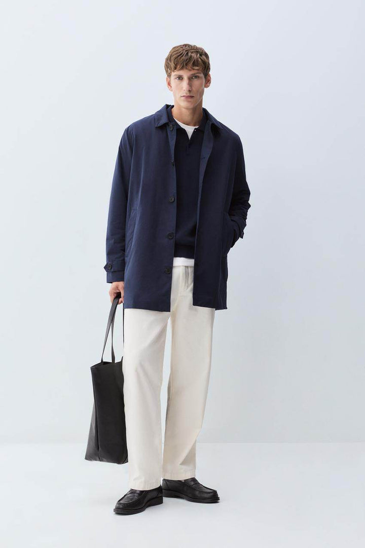 Full body front view of man wearing navy padded trench coat

