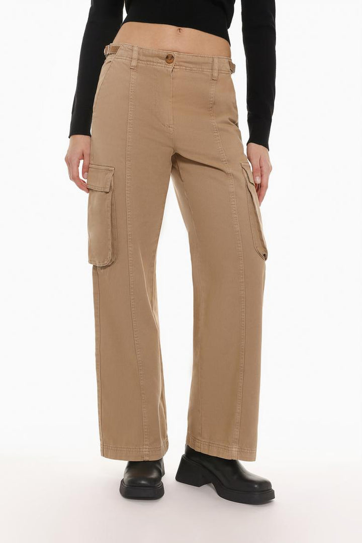 Front view of the beige oversize cargo trousers, emphasizing the buckle accents and functional design.