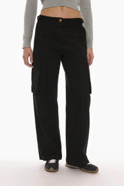 Front view of the black oversize cargo trousers, featuring bold buckle details and functional pockets.