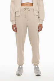Front view of the beige oversized tracksuit trousers, showcasing the relaxed fit and simple design.