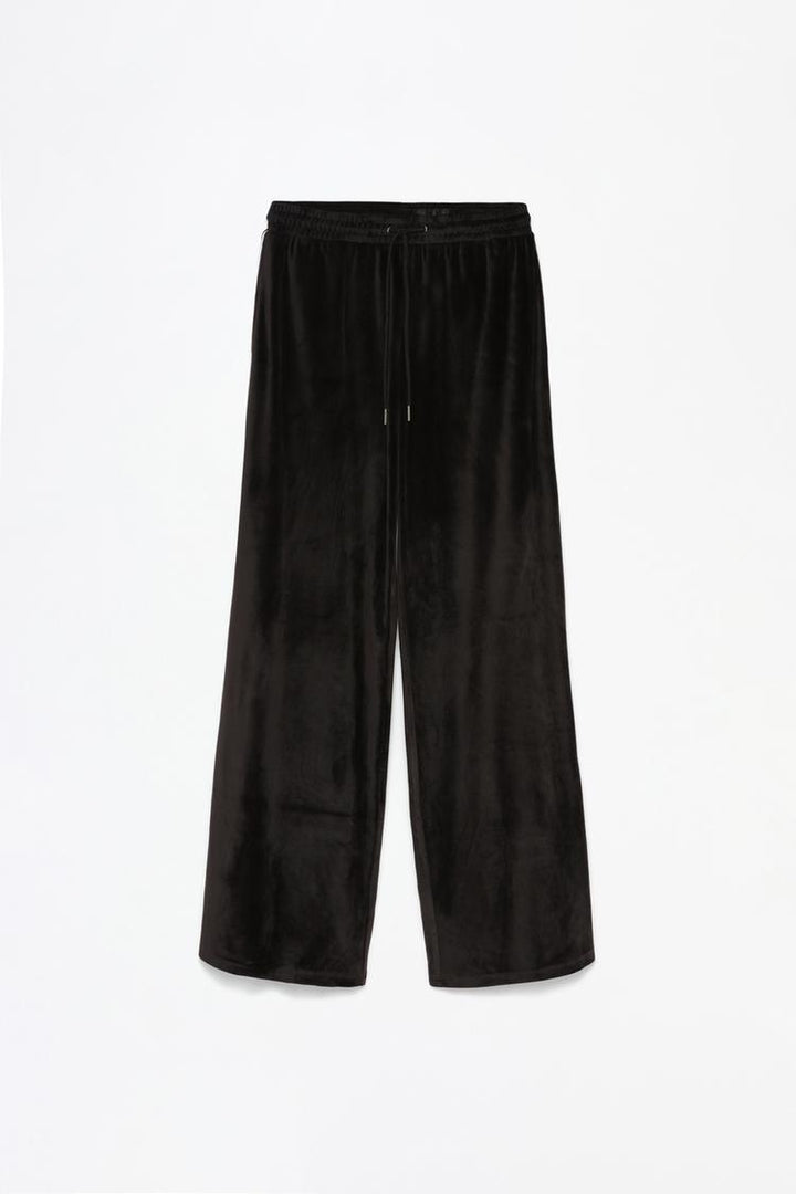 Full product view of black oversized velvet trousers displaying the complete design.