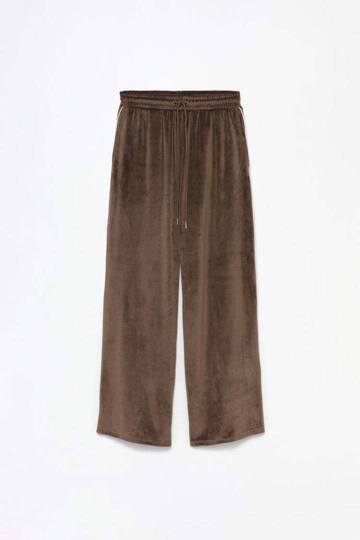 Product view of brown oversized velvet trousers showing fabric and styling.