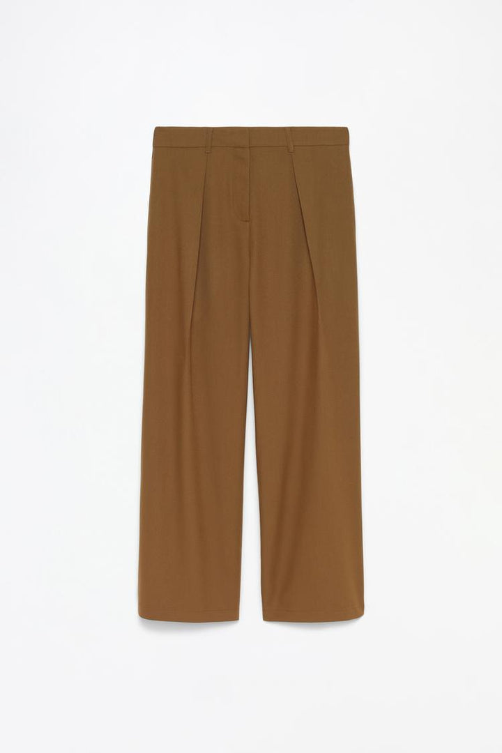 Full product shot of the brown pleated wide-leg trousers, providing a detailed view of the fabric, pleats, and overall design.