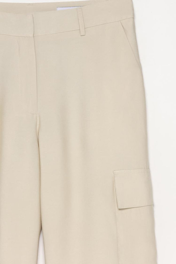 Close-up view of the cargo trousers, detailing the premium material and precise stitching.