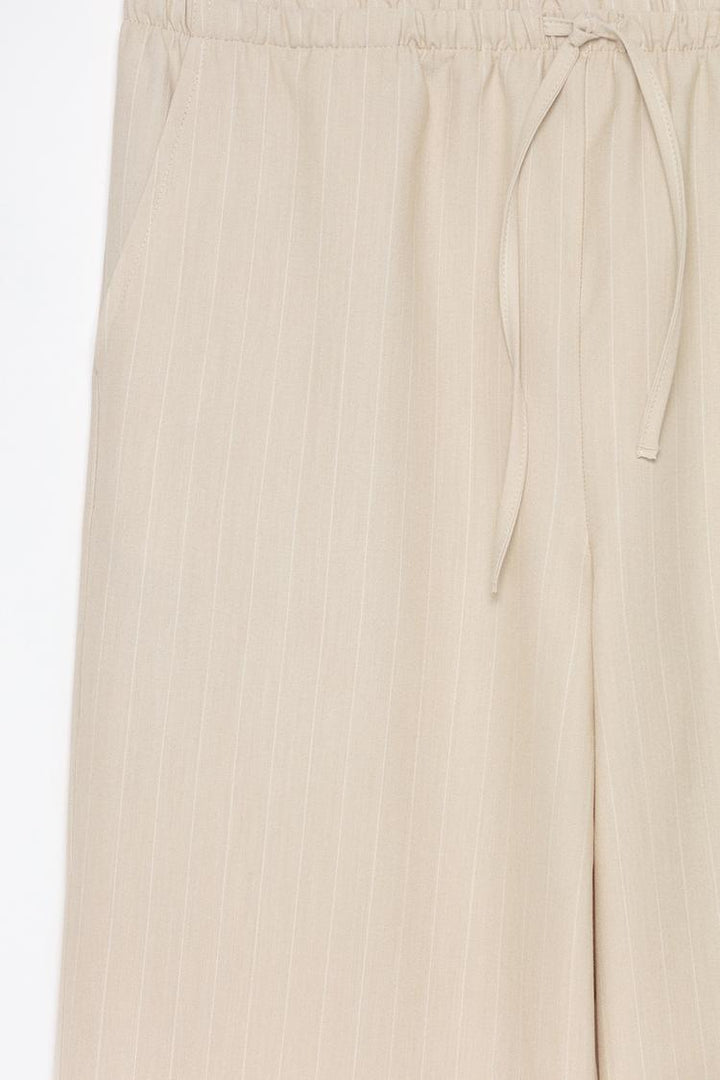 Detailed product display of beige straight-fit trousers, perfect for casual and office wear