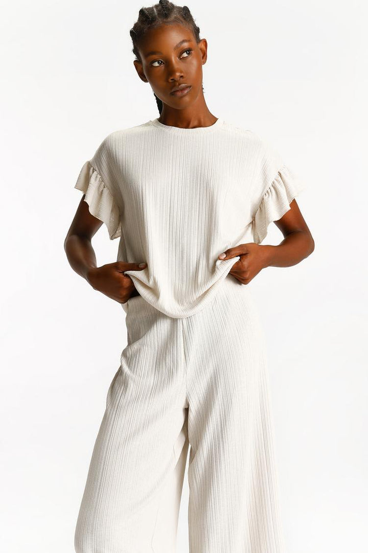 Outfit styled with the beige textured culottes, demonstrating their adaptability for various occasions.