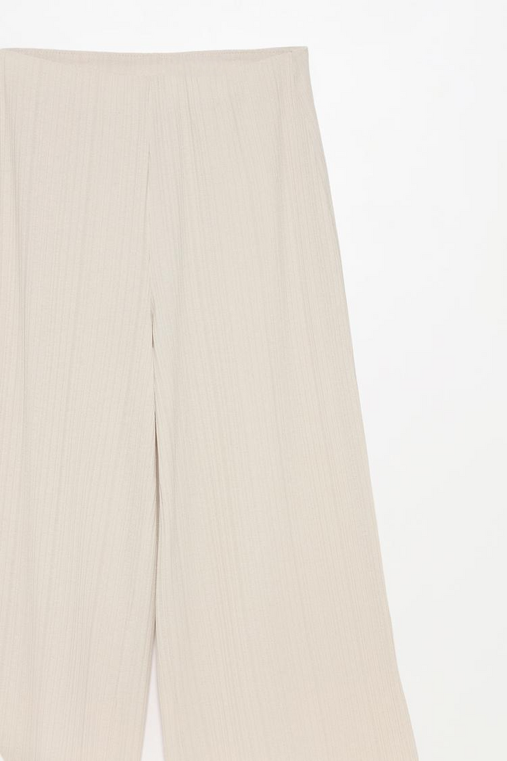 Comprehensive product view of the beige textured culottes, showcasing texture and tailoring.