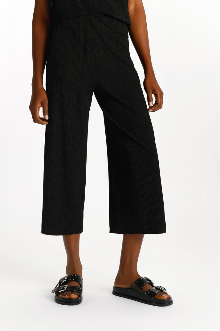 Detailed shot of the beige textured culottes, focusing on the fabric and elegant design.