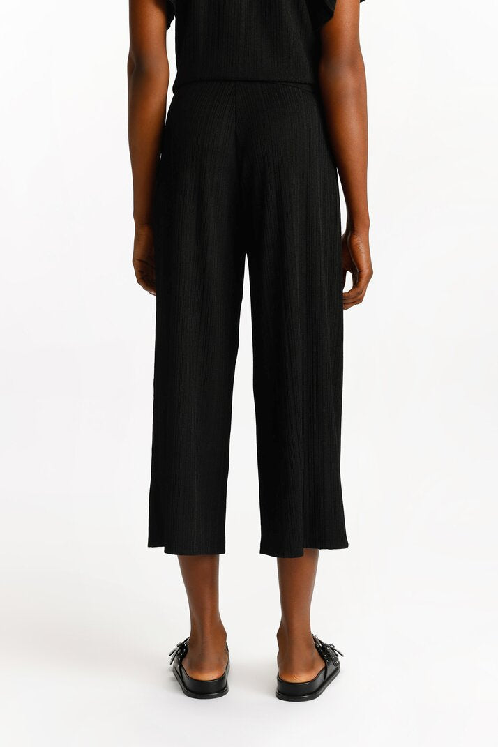 Front view of the black textured culottes, highlighting their structured waistband and textured fabric.