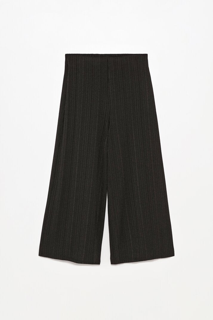Full-body view of the black textured culottes, styled for a contemporary and chic outfit.