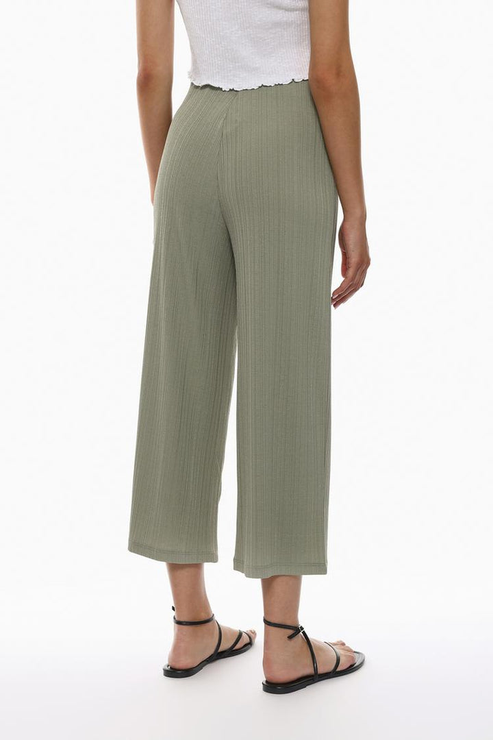 Rear view of the green textured culottes, showcasing their clean lines and tailored fit.