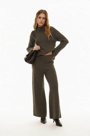 Showcasing textured knit trousers in green, emphasizing the rich knit pattern and comfortable fit.