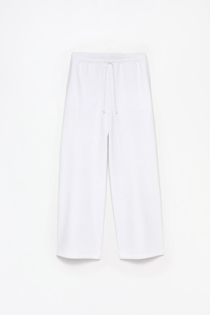 Product view of white wide-leg plush trousers showing fabric and styling.