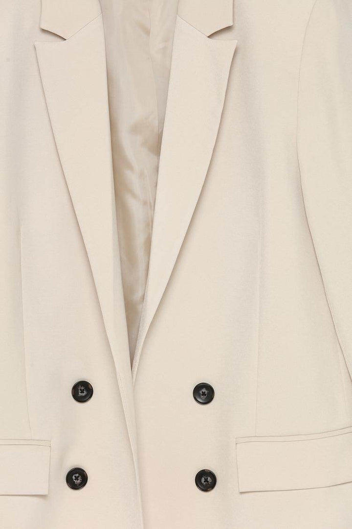 Close-up product image of beige blazer details

