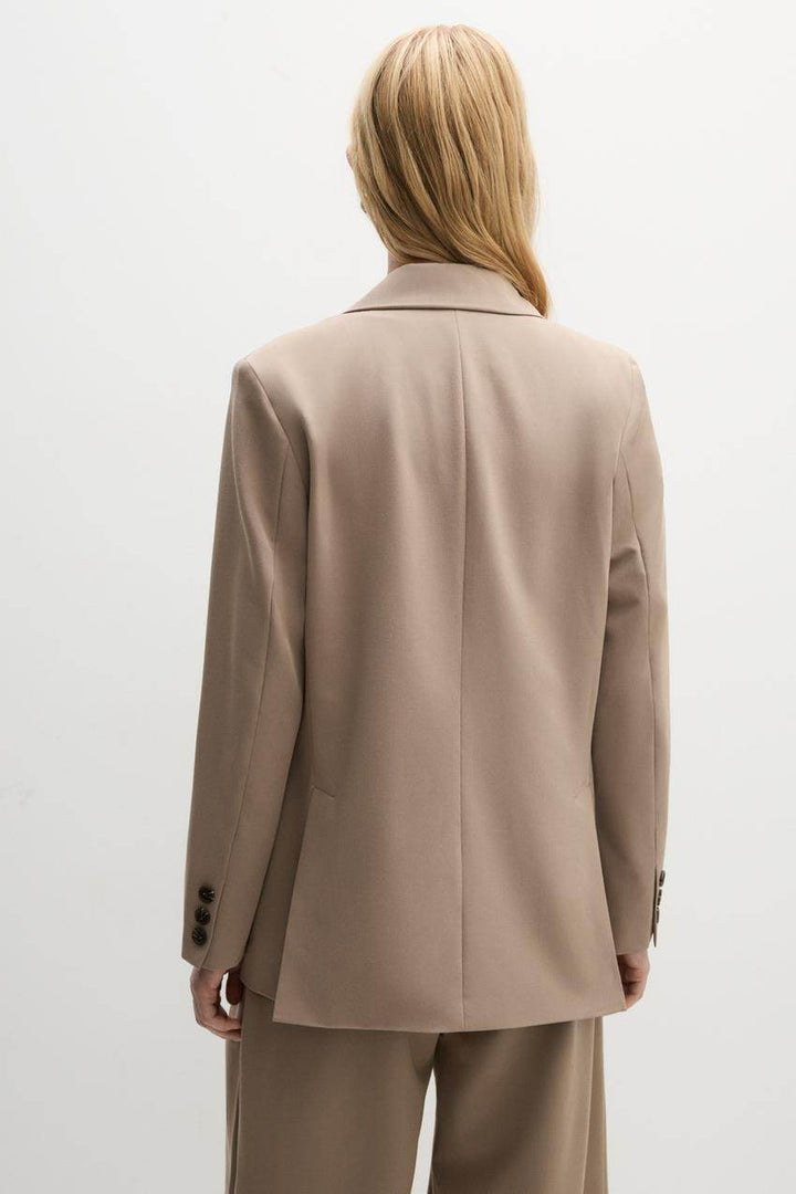 Back view of a beige women's blazer
