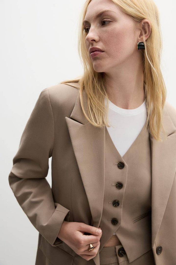 Zoomed front view of a beige women's blazer

