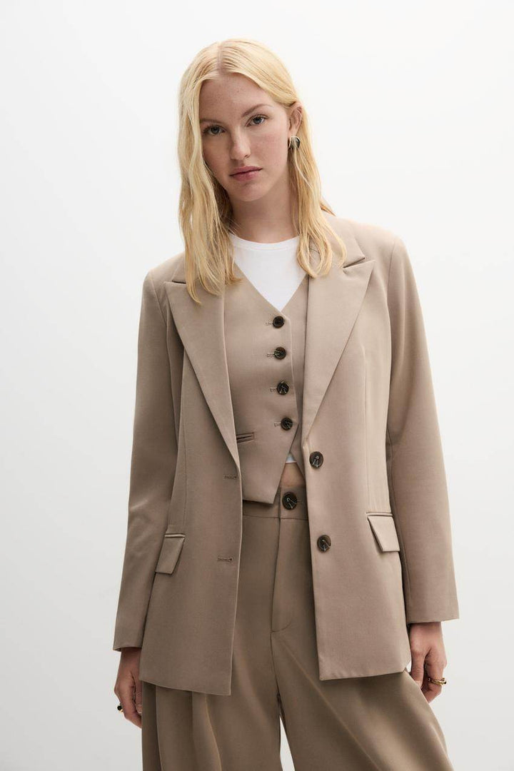 Zoomed front view of a beige women's blazer
