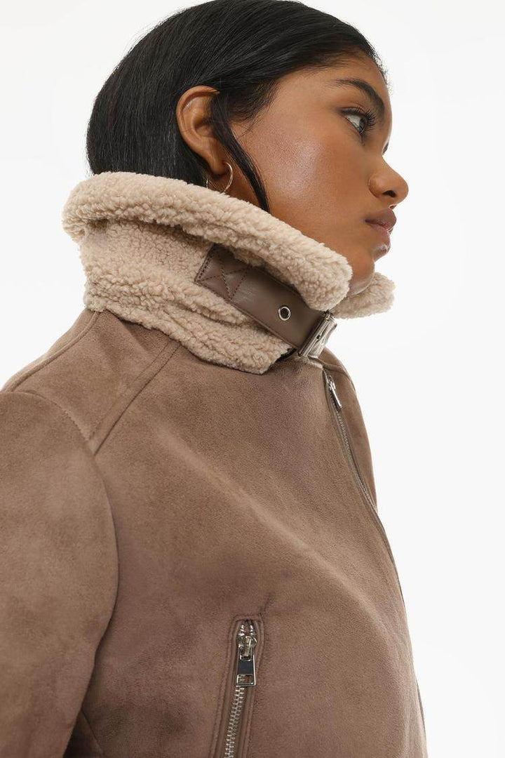 Model side view showcasing beige crossover jacket


