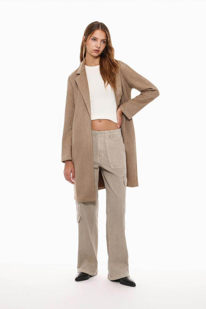 Full body front view of woman wearing beige faux suede coat

