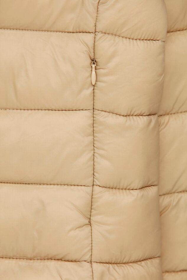 Close-up of beige lightweight puffer jacket fabric texture

