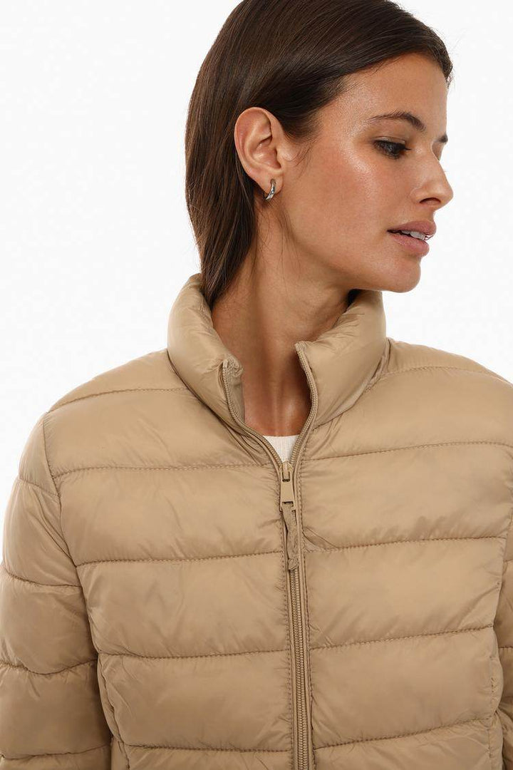 Model showcasing beige lightweight puffer jacket front

