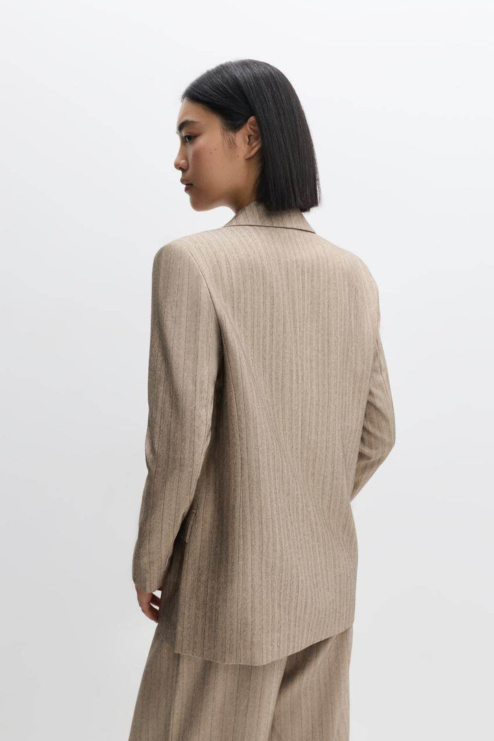 Side view of a beige women's pinstripe blazer
