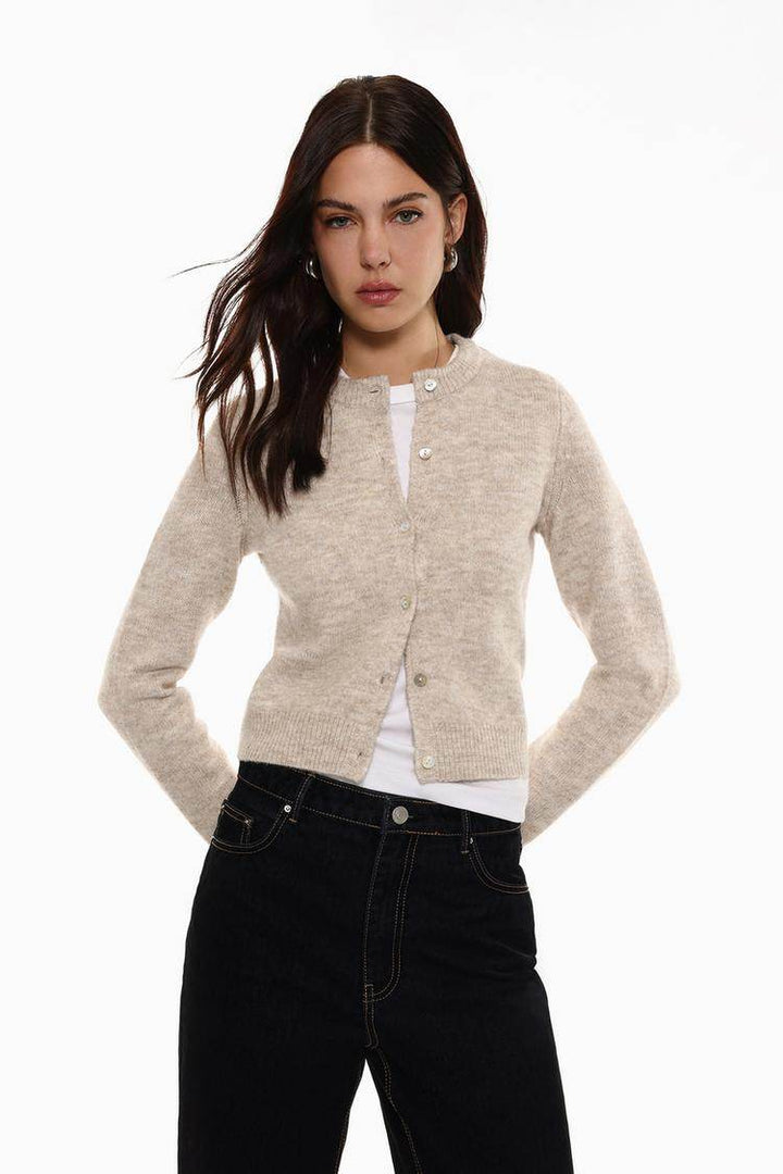 Front view of women's beige rounded neck knit cardigan

