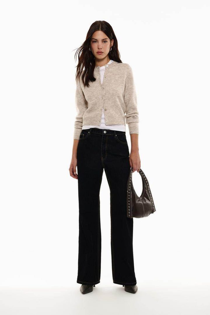 Full body front view of woman wearing beige knit cardigan

