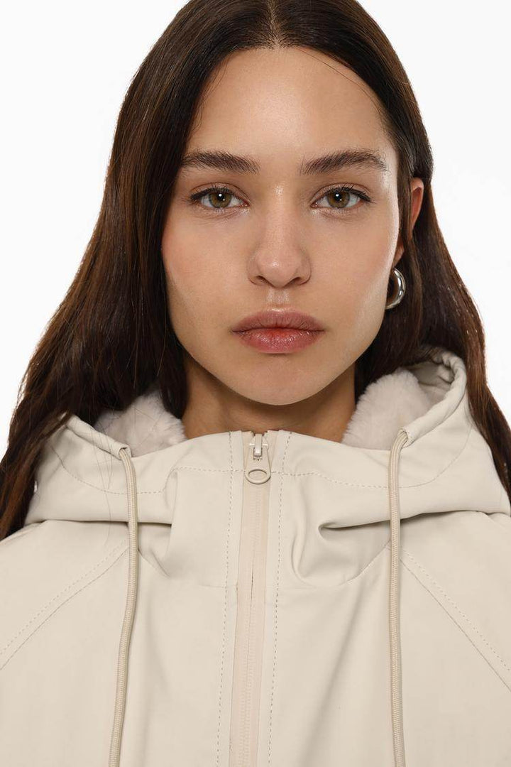 Close-up front view of beige rubberised parka

