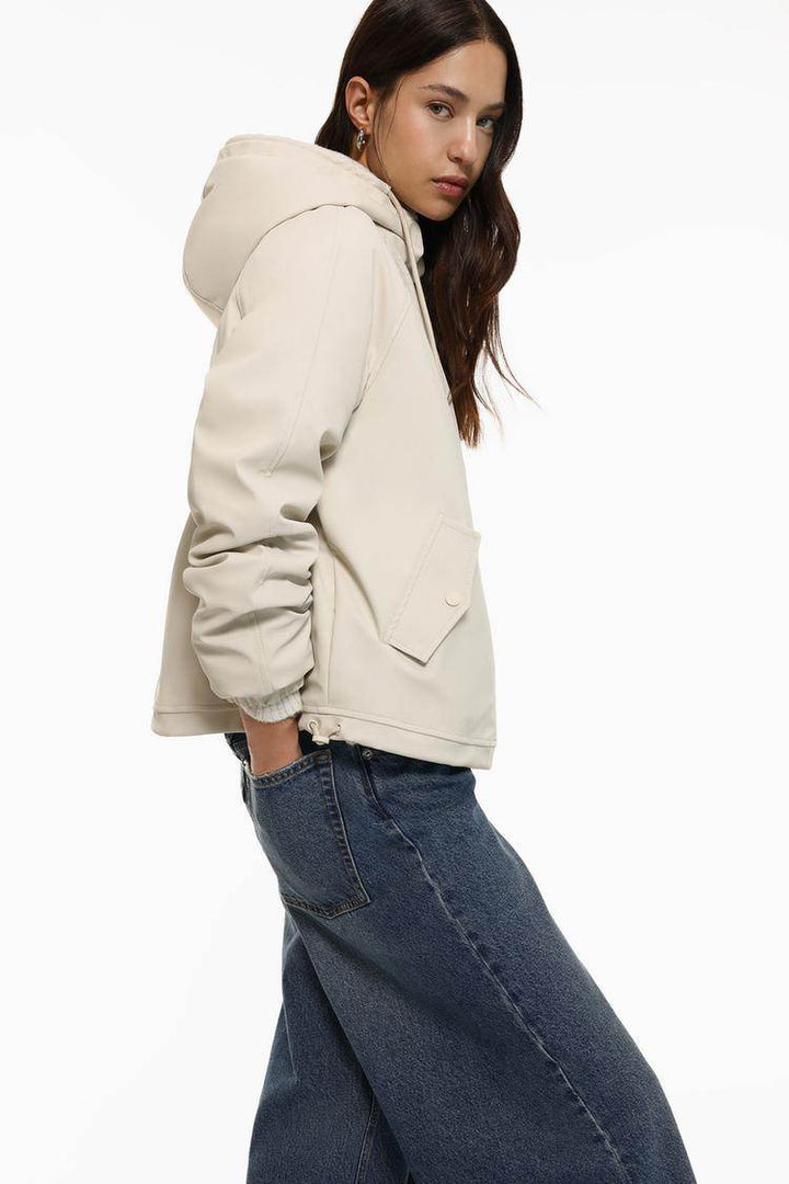 Side view of women's beige rubberised parka with faux fur lining

