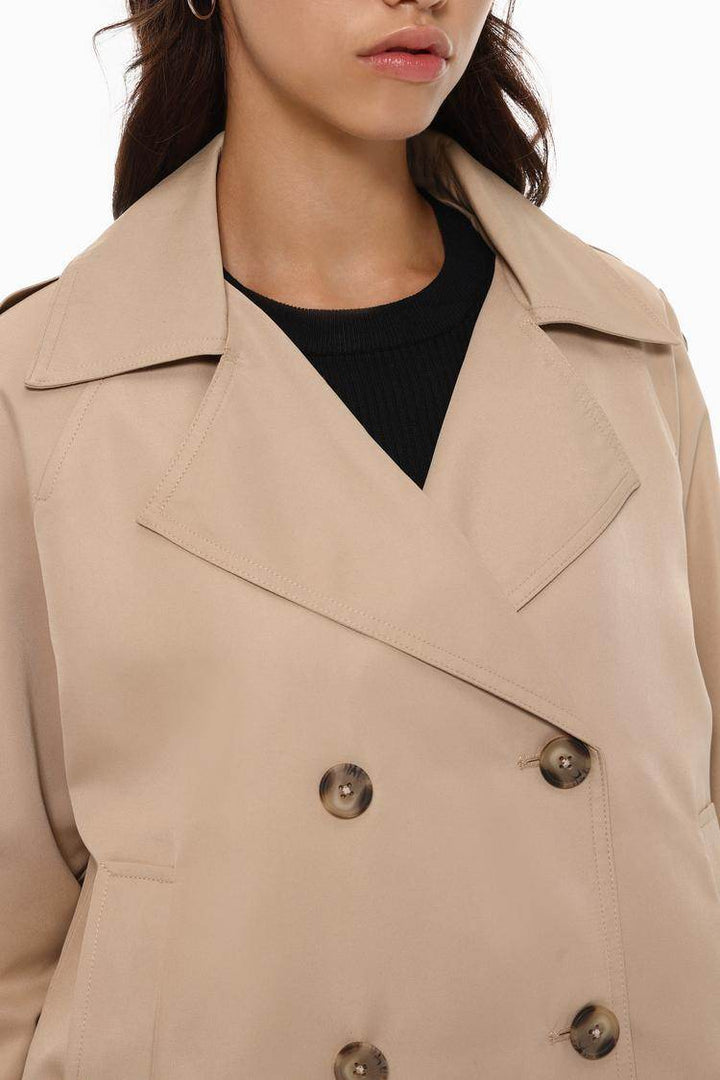 Close-up front view of beige trench coat details

